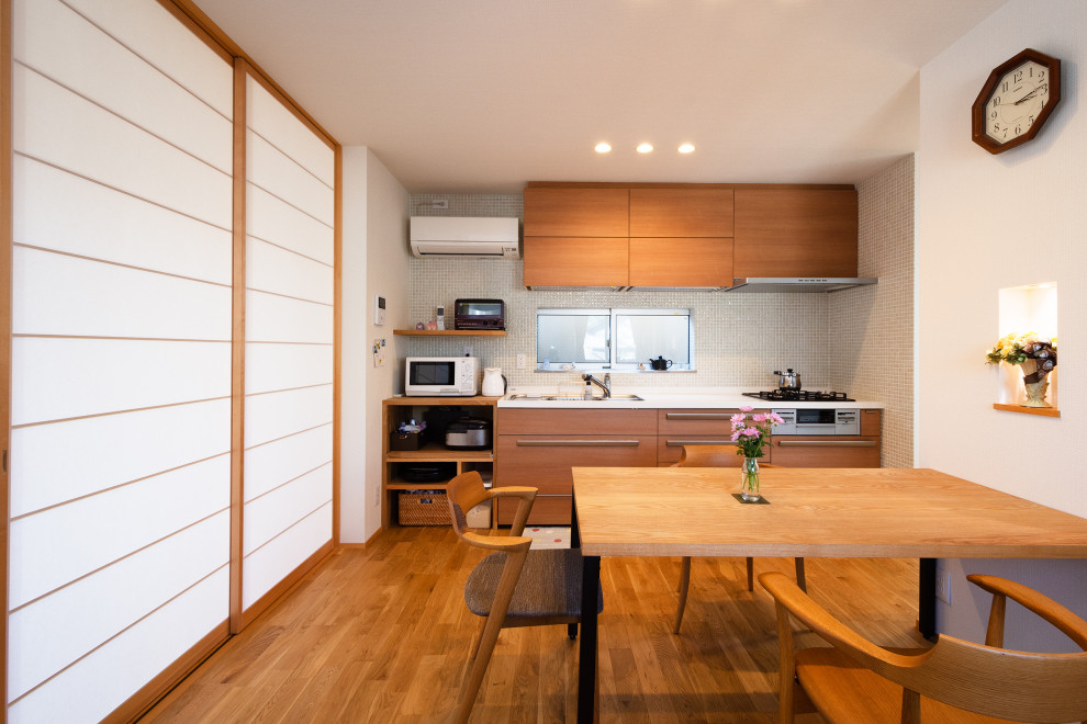 Стильный дизайн: кухня-столовая среднего размера в стиле модернизм с белыми стенами, паркетным полом среднего тона, потолком с обоями и обоями на стенах без камина - последний тренд