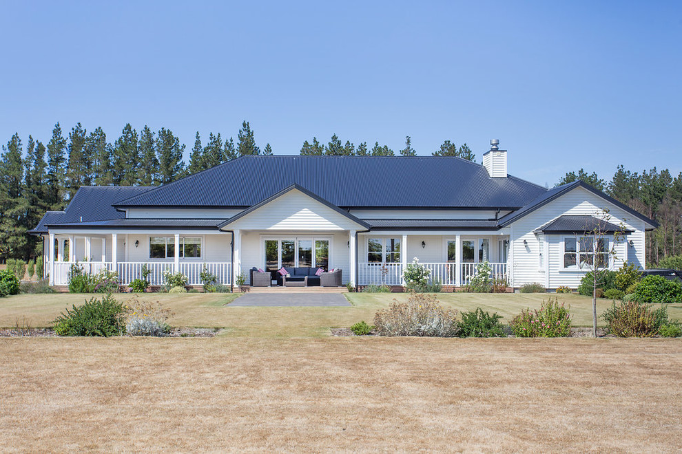 Inspiration for an Expansive country One-storey White house exterior in Christchurch With Mixed Siding and a Hip Roof.