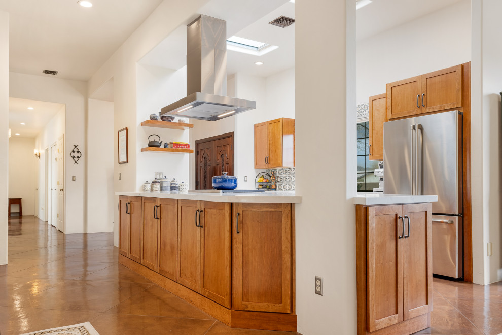 Idéer för att renovera ett mellanstort amerikanskt vit vitt kök, med en rustik diskho, skåp i shakerstil, bruna skåp, bänkskiva i kvarts, orange stänkskydd, stänkskydd i keramik, rostfria vitvaror, betonggolv, en halv köksö och brunt golv