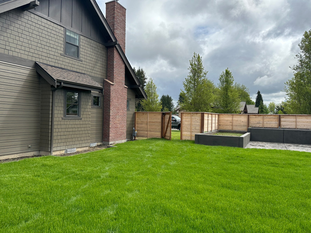 Foto di un giardino contemporaneo di medie dimensioni e dietro casa con pavimentazioni in cemento e recinzione in legno