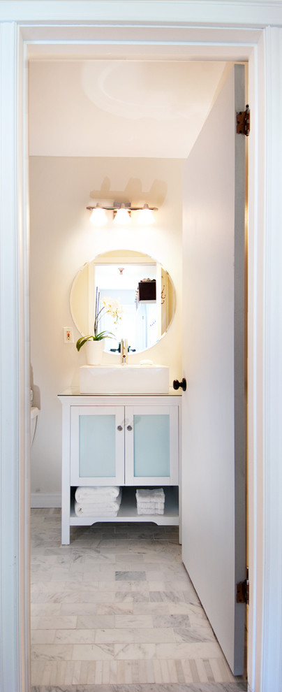 Inspiration for a small transitional 3/4 bathroom in Toronto with a vessel sink, raised-panel cabinets, white cabinets, glass benchtops, an alcove shower, a two-piece toilet, white tile, stone tile, white walls and marble floors.