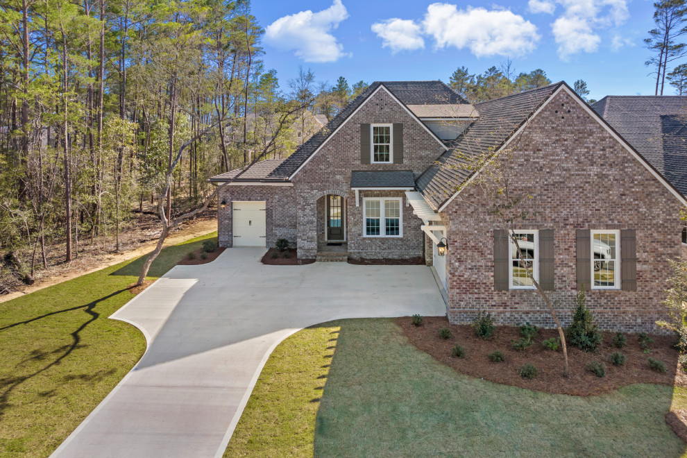 Transitional brown two-story brick house exterior idea with a shingle roof