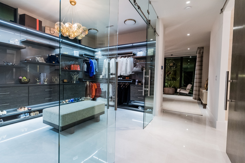 Expansive modern dressing room in Miami with flat-panel cabinets, dark wood cabinets, marble floors and grey floor.