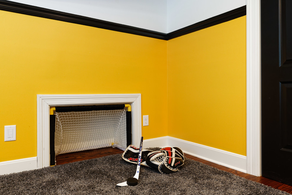 Photo of a traditional bedroom in Cincinnati with yellow walls, medium hardwood floors and brown floor.