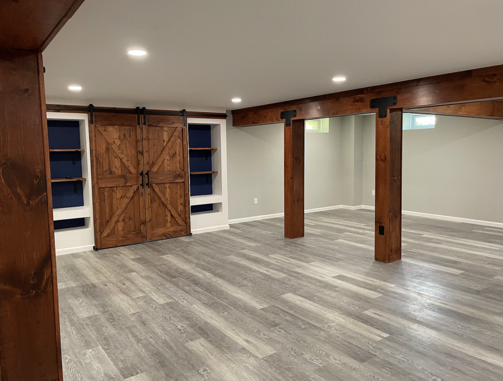 Medium sized industrial look-out basement in New York with a game room, grey walls, vinyl flooring, no fireplace, grey floors and exposed beams.