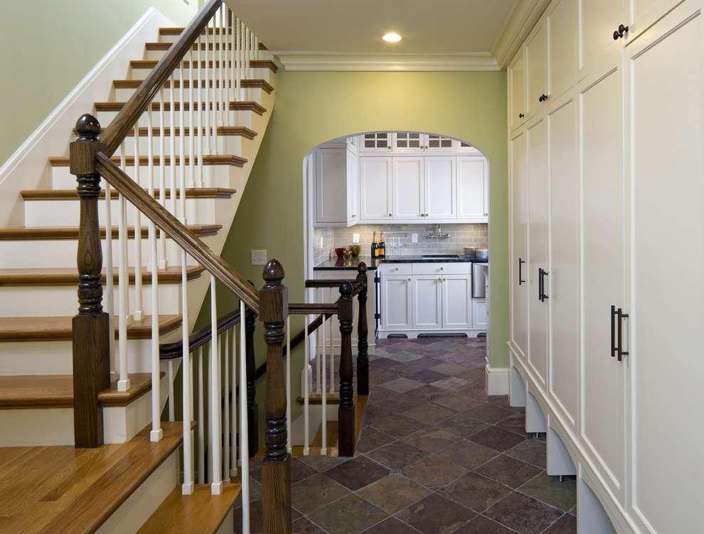 This is an example of a traditional entryway in Boston with green walls and slate floors.
