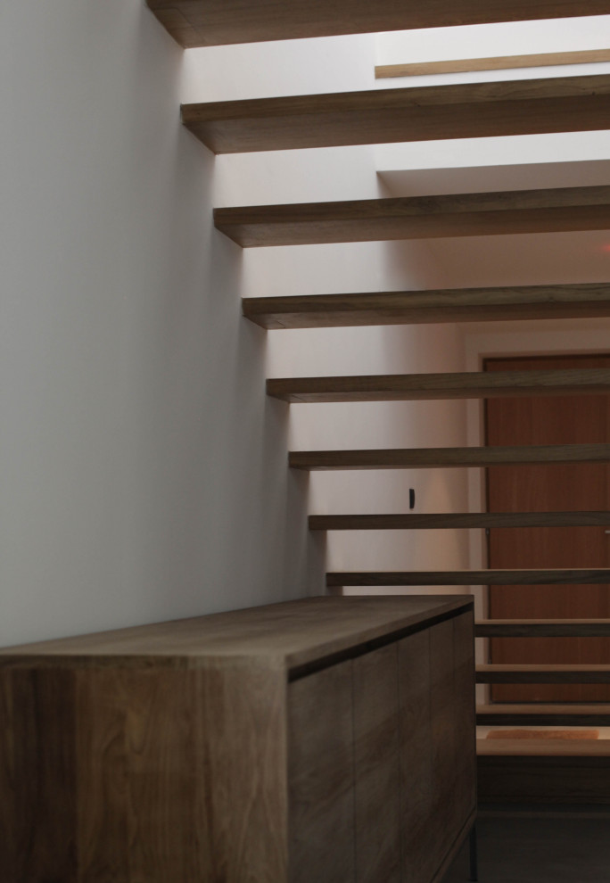 Idées déco pour un grand escalier sans contremarche droit contemporain avec des marches en bois et un garde-corps en bois.
