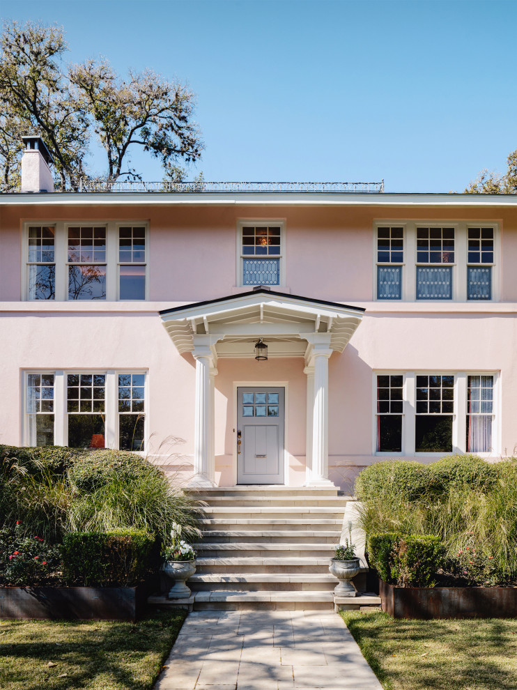 Inspiration for an expansive traditional two-storey stucco pink house exterior in Austin with a gable roof and a metal roof.