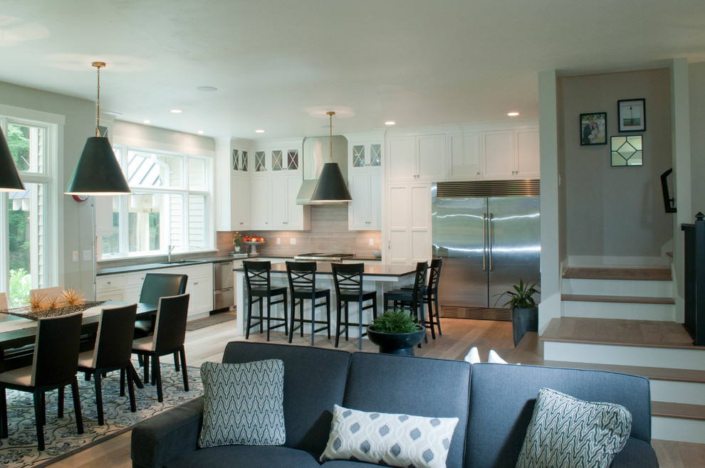 Inspiration for a mid-sized transitional l-shaped light wood floor and beige floor eat-in kitchen remodel with an undermount sink, shaker cabinets, white cabinets, solid surface countertops, multicolored backsplash, porcelain backsplash, stainless steel appliances and an island