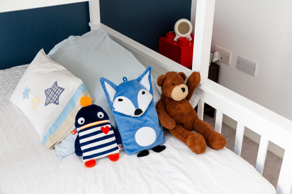 Modelo de dormitorio infantil moderno pequeño con paredes azules, moqueta y suelo beige
