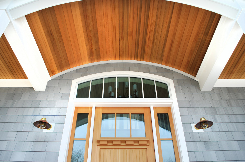 Imagen de fachada de casa gris costera grande de dos plantas con revestimiento de madera y teja