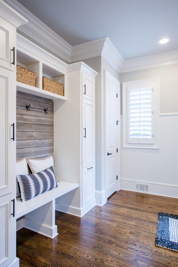 Example of a mid-sized transitional medium tone wood floor and brown floor mudroom design in Atlanta with multicolored walls and a dark wood front door
