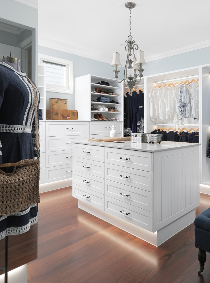 Expansive beach style gender-neutral walk-in wardrobe in Sunshine Coast with shaker cabinets, white cabinets, dark hardwood floors and brown floor.