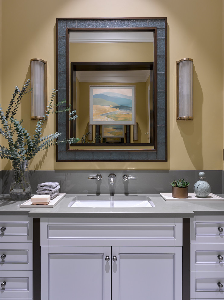 Photo of a mid-sized transitional bathroom in Moscow with white cabinets, ceramic tile, yellow walls, engineered quartz benchtops, recessed-panel cabinets and an undermount sink.