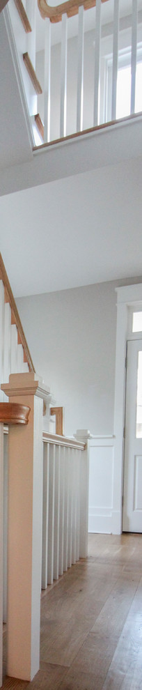 This is an example of a large traditional wood l-shaped staircase in DC Metro with wood risers and wood railing.