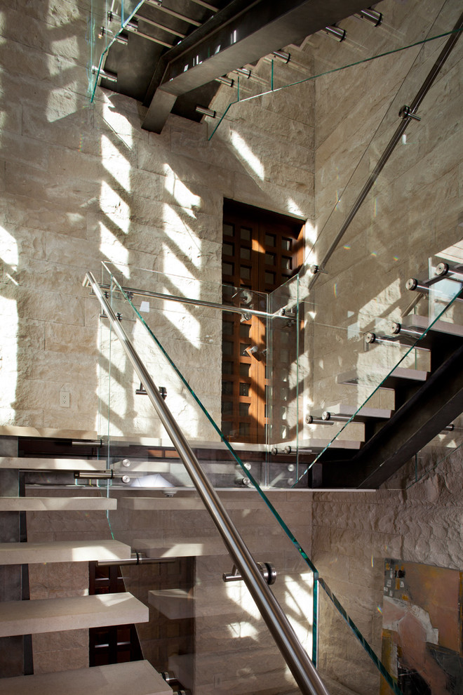 Photo of a mid-sized contemporary limestone u-shaped staircase in San Francisco with open risers and glass railing.