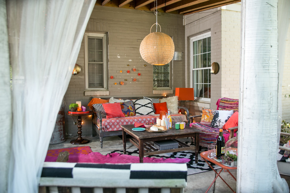 Small eclectic backyard patio in Raleigh with a roof extension and concrete slab.