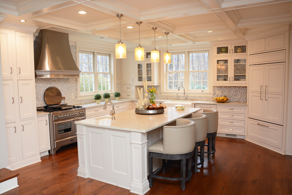 Inspiration for a large u-shaped open plan kitchen in Baltimore with a farmhouse sink, recessed-panel cabinets, white cabinets, quartz benchtops, grey splashback, stainless steel appliances, medium hardwood floors, with island, brown floor, white benchtop and coffered.