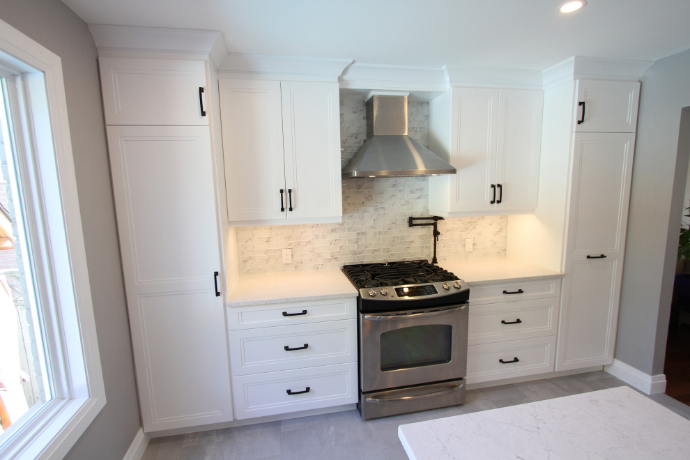 Design ideas for a mid-sized contemporary l-shaped eat-in kitchen in Toronto with an undermount sink, recessed-panel cabinets, white cabinets, quartz benchtops, grey splashback, glass tile splashback, stainless steel appliances, porcelain floors, with island, grey floor and white benchtop.