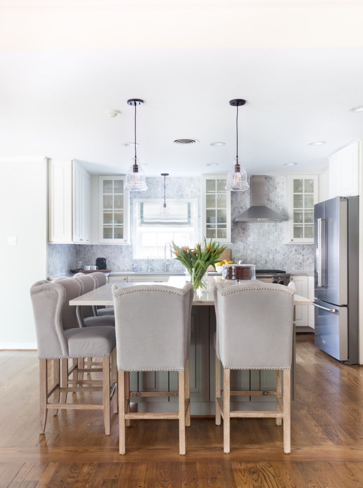 Mid-sized transitional u-shaped open plan kitchen in Other with an undermount sink, raised-panel cabinets, white cabinets, solid surface benchtops, grey splashback, glass tile splashback, stainless steel appliances, dark hardwood floors, with island, brown floor and white benchtop.