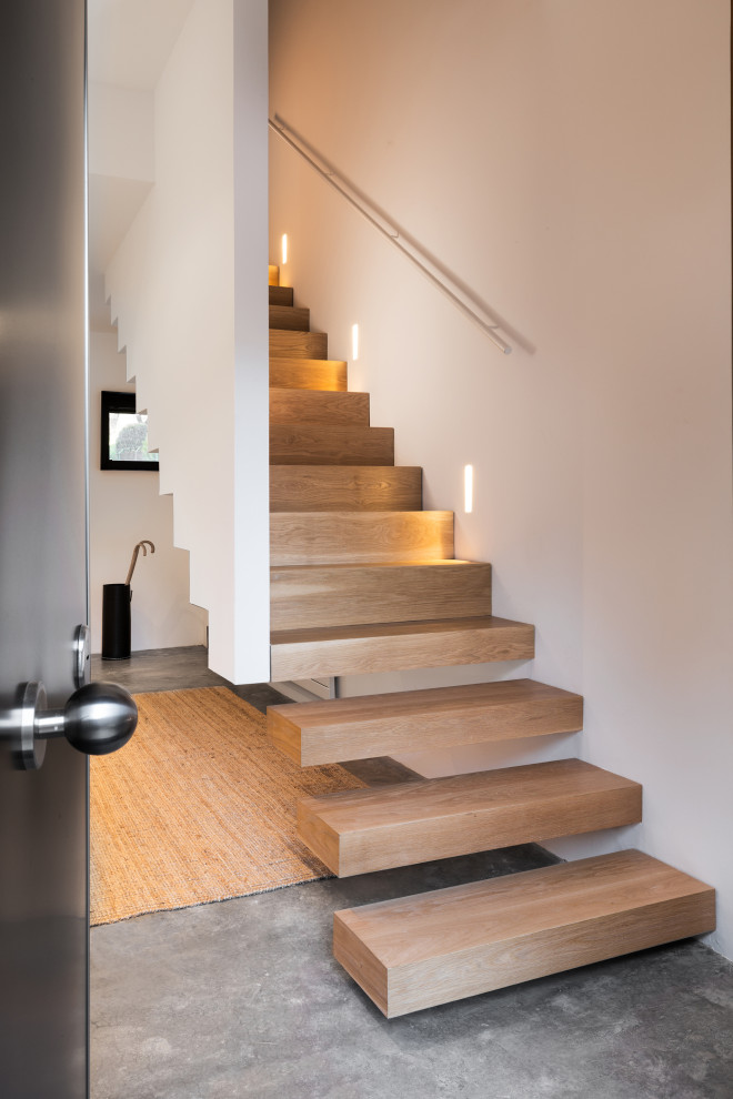 Große, Gerade Moderne Holztreppe mit offenen Setzstufen, Stahlgeländer und Wandpaneelen in Sonstige