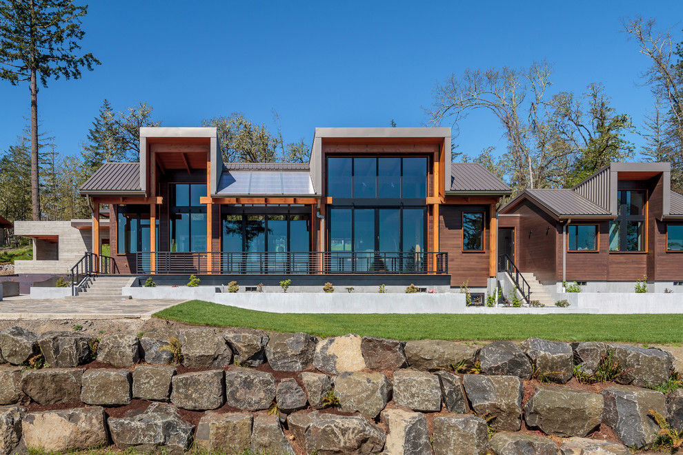 Inspiration for a rustic brown wood house exterior remodel with a metal roof