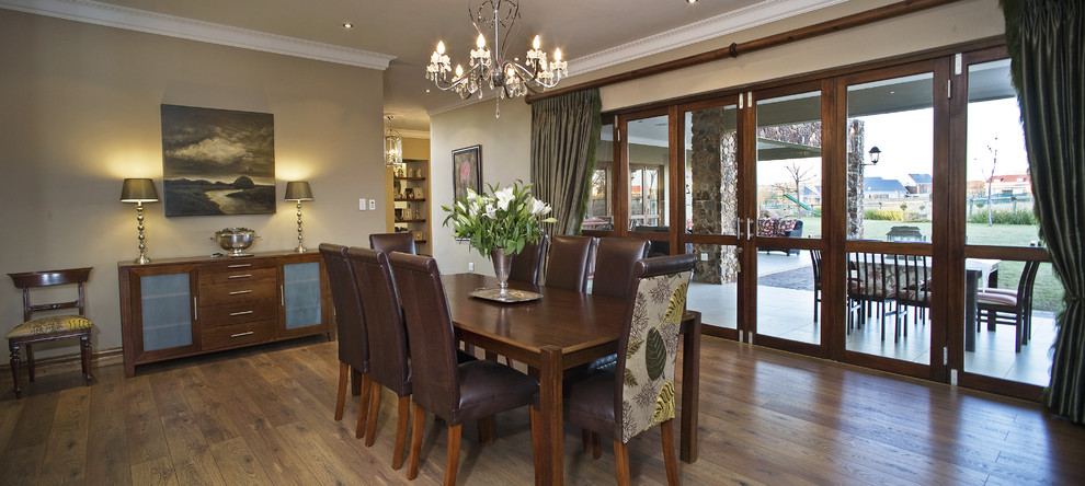 Traditional dining room in Other with beige walls and dark hardwood floors.