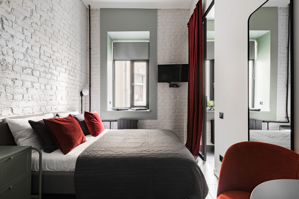 Стильный дизайн: гостевая спальня среднего размера, (комната для гостей) в стиле лофт с белыми стенами, полом из керамогранита, серым полом и кирпичными стенами - последний тренд