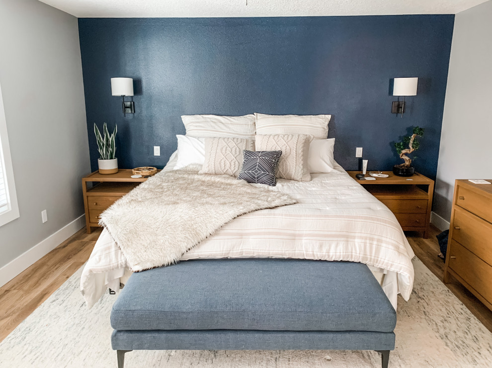 Идея дизайна: большая хозяйская спальня в современном стиле с синими стенами, полом из ламината и коричневым полом
