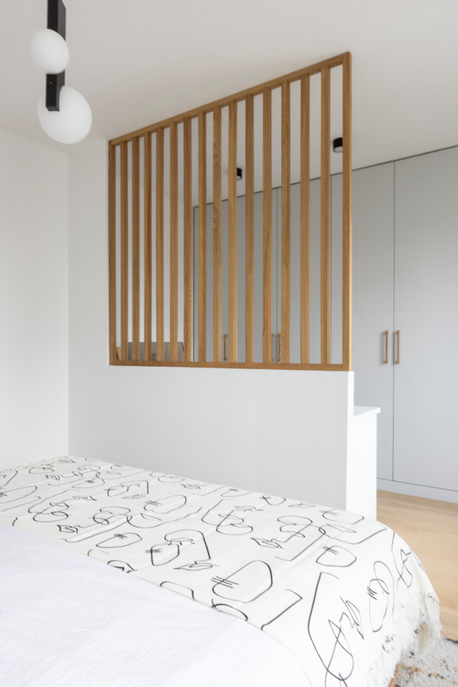 Пример оригинального дизайна: хозяйская спальня среднего размера, в белых тонах с отделкой деревом в современном стиле с белыми стенами и светлым паркетным полом