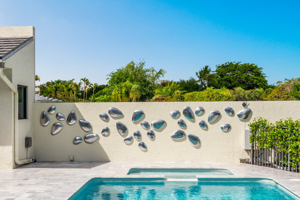 Inspiration för stora moderna l-formad pooler på baksidan av huset, med spabad och naturstensplattor