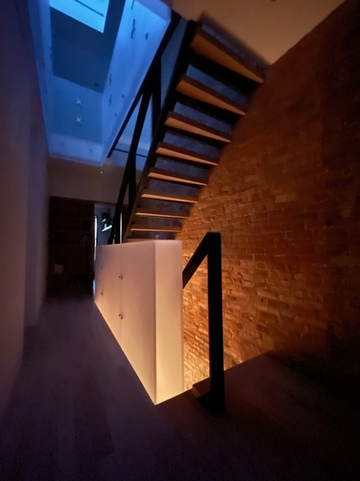 Example of a small minimalist metal railing and brick wall staircase design in New York
