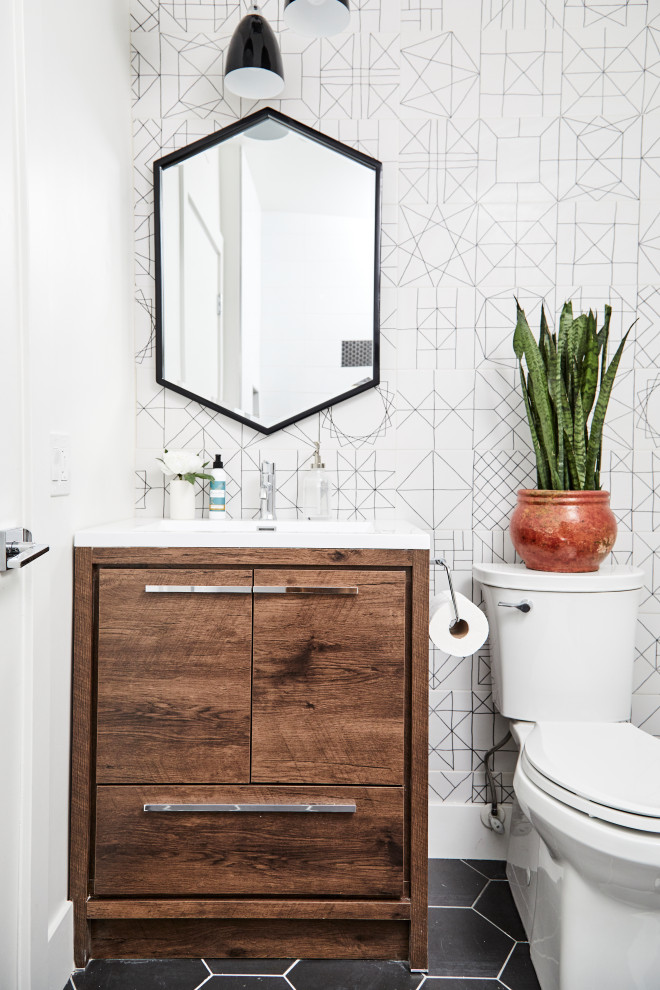 Midcentury powder room in Los Angeles with flat-panel cabinets, dark wood cabinets, a two-piece toilet, white walls, a console sink, black floor, white benchtops, a built-in vanity and wallpaper.