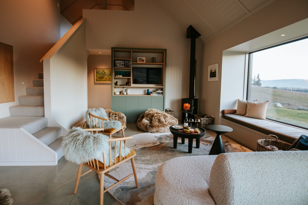 Mid-sized country Loft-style living room With Green Walls, Porcelain Floors, a Corner Fireplace, a Wall-mounted TV, Grey Floor, Vaulted and Panelled Walls.