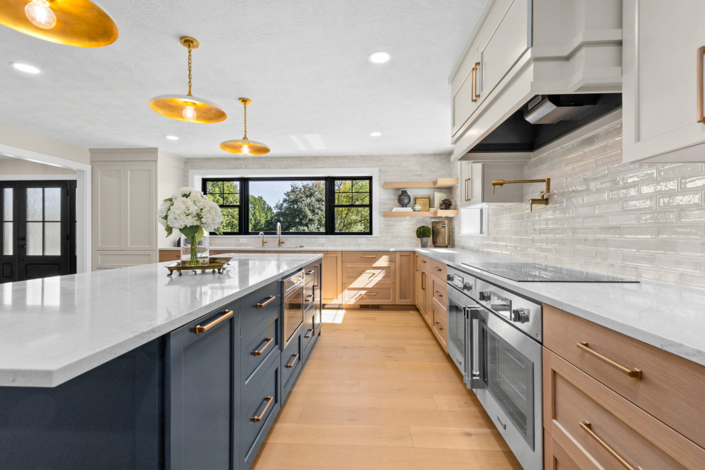 Example of a mid-sized transitional u-shaped open concept kitchen design with recessed-panel cabinets, white cabinets and an island