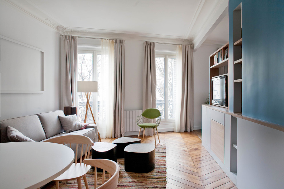 Salle à manger ouverte sur le salon?[Cette photo montre salle à manger ouverte sur le salon With un téléviseur fixé au mur, un mur bleu, parquet foncé and un sol marron.]:[Cette photo montre salles à manger ouvertes sur le salon With un téléviseur fixé au mur, un mur bleu, parquet foncé and un sol marron.]