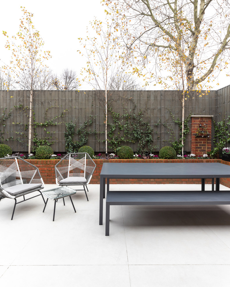 Photo of a contemporary patio in London with tile and no cover.