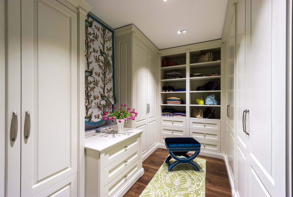 Design ideas for a mid-sized traditional gender-neutral dressing room in Moscow with white cabinets, dark hardwood floors, raised-panel cabinets and brown floor.