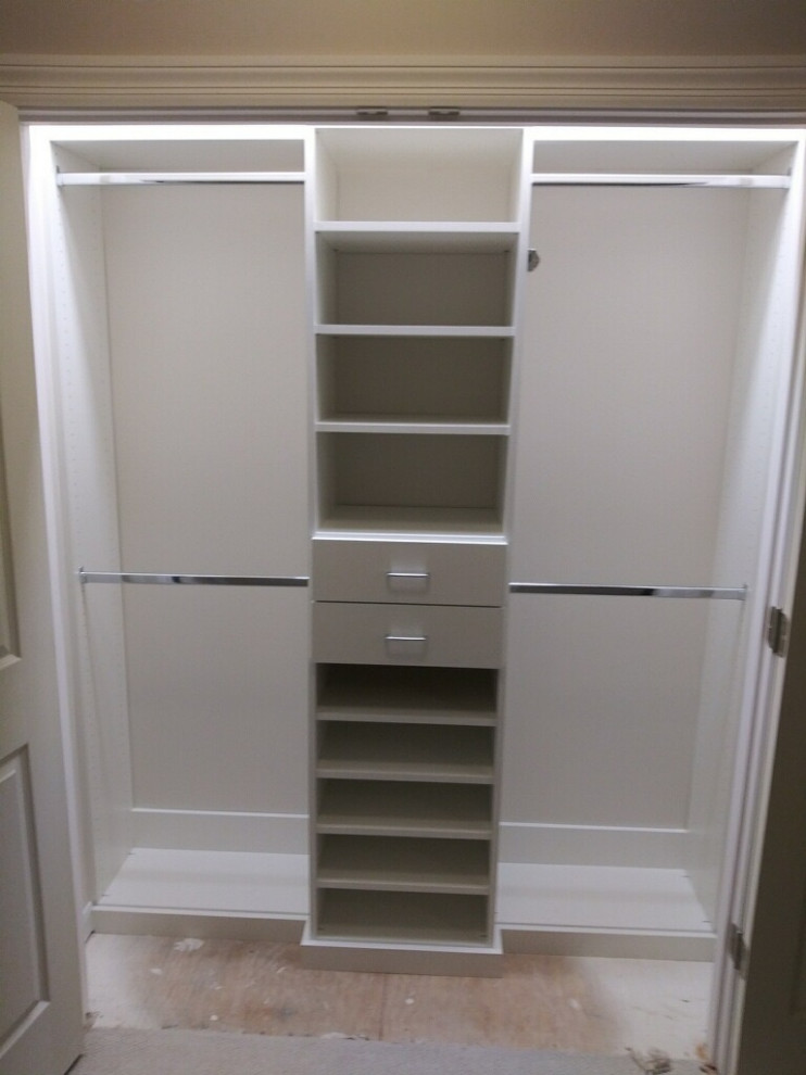 This is an example of a small transitional built-in wardrobe in St Louis with flat-panel cabinets and white cabinets.
