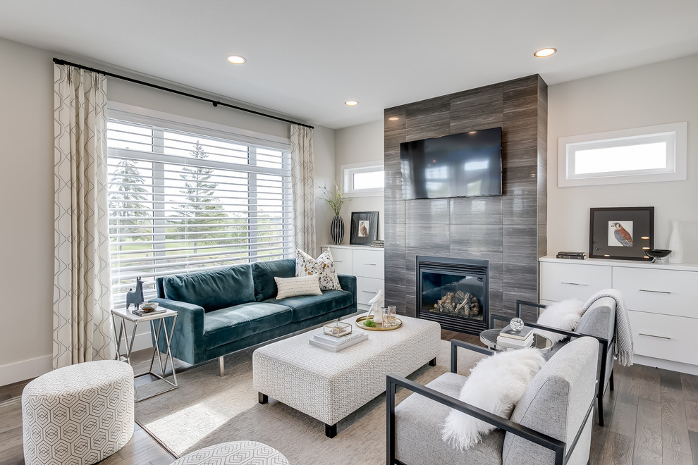 Mid-sized contemporary open concept living room in Other with medium hardwood floors, a standard fireplace, a tile fireplace surround and a wall-mounted tv.
