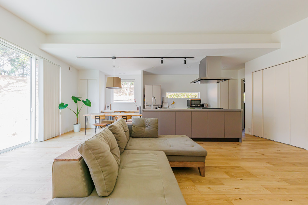 Großes, Offenes Modernes Wohnzimmer ohne Kamin mit weißer Wandfarbe, hellem Holzboden, TV-Wand, beigem Boden, Tapetendecke und Tapetenwänden in Kobe