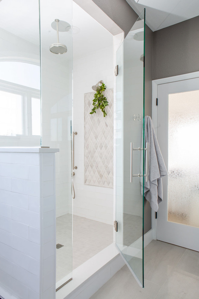 Inspiration for an expansive transitional master bathroom in Denver with shaker cabinets, white cabinets, a freestanding tub, a corner shower, a one-piece toilet, white tile, ceramic tile, grey walls, porcelain floors, an undermount sink, engineered quartz benchtops, grey floor, a hinged shower door and white benchtops.