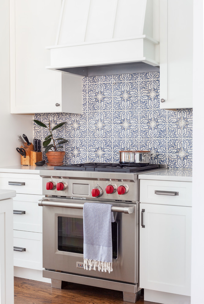 Example of a transitional dark wood floor and brown floor kitchen design in Chicago with shaker cabinets, white cabinets, quartzite countertops, multicolored backsplash, stone tile backsplash, stainless steel appliances, an island and white countertops