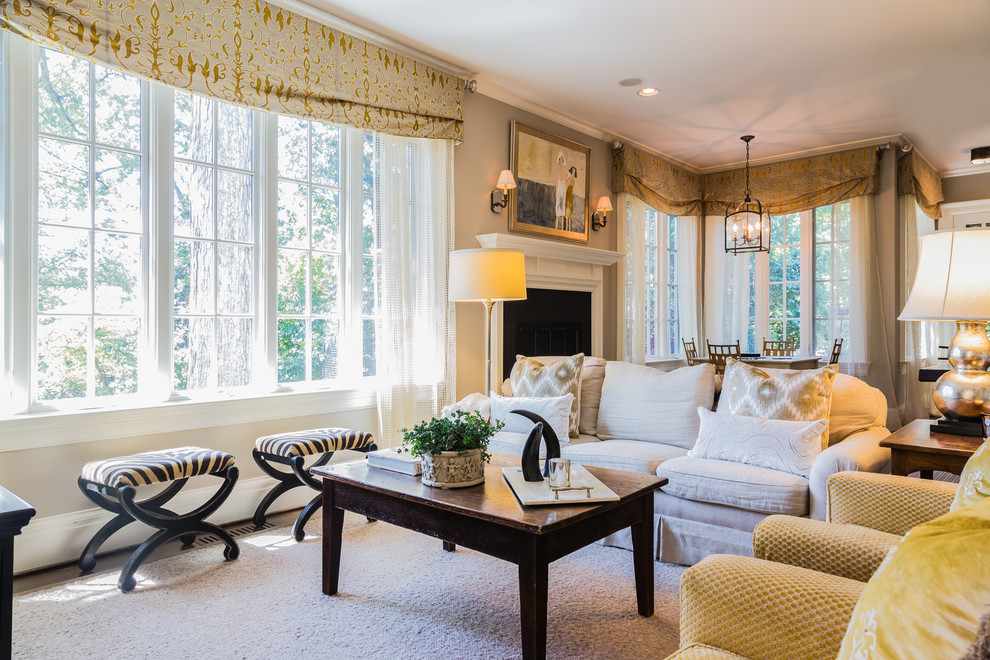 This is an example of a transitional formal living room in Raleigh with beige walls, carpet, a standard fireplace and a wood fireplace surround.