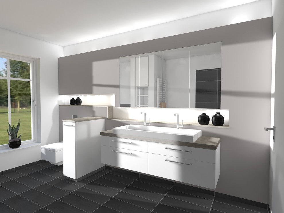 Badezimmer With flächenbündigen Schrankfronten, weißen Schränken, freistehender Badewanne, bodengleicher Dusche, Wandtoilette mit Spülkasten, grauen Fliesen, Steinplatten, weißer Wandfarbe, Schieferboden, Aufsatzwaschbecken, Granit-Waschbecken/Waschtisch, grauem Boden and offener Dusche in Bremen