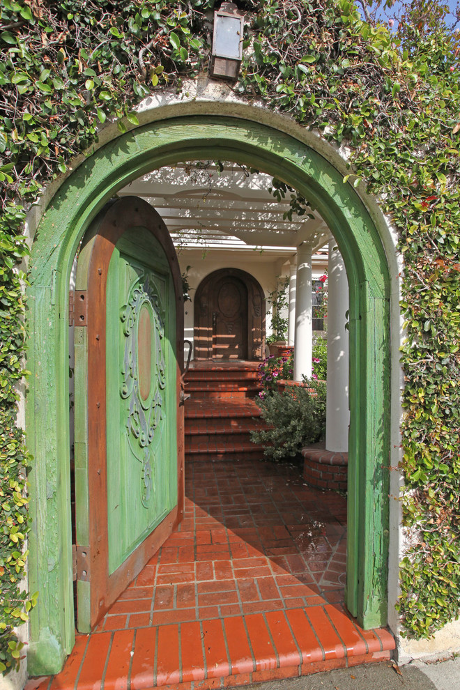 This is an example of an eclectic entryway in Los Angeles with a single front door and a green front door.