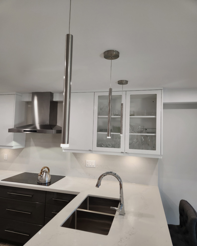 This is an example of a mid-sized contemporary l-shaped eat-in kitchen in Toronto with an undermount sink, flat-panel cabinets, yellow cabinets, quartz benchtops, white splashback, engineered quartz splashback, stainless steel appliances, medium hardwood floors, a peninsula, brown floor and white benchtop.