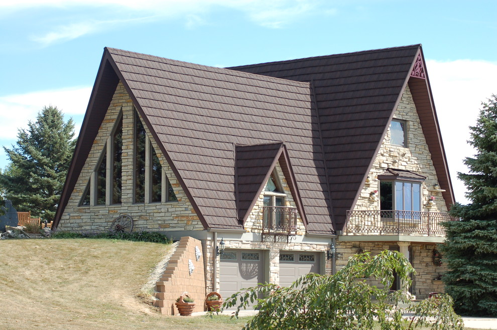 This is an example of a country three-storey house exterior in Cedar Rapids with a gable roof and a metal roof.