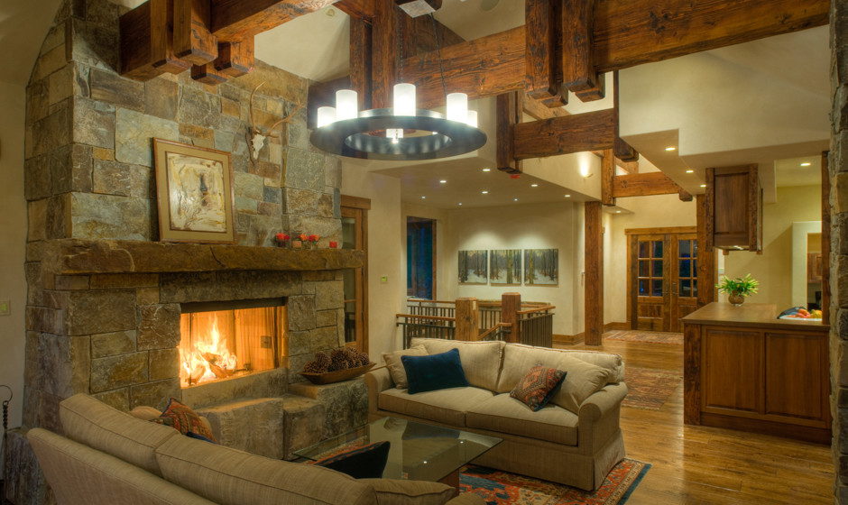 Design ideas for a large country open concept living room in Denver with beige walls, medium hardwood floors, a standard fireplace, a stone fireplace surround and no tv.