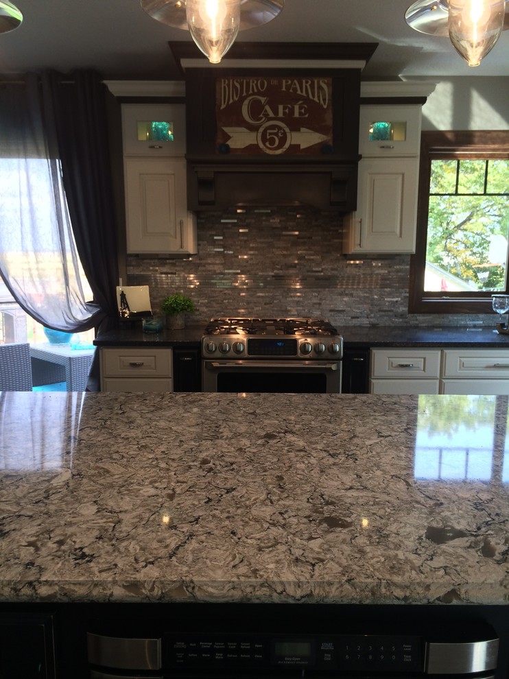 Example of a large mountain style l-shaped eat-in kitchen design with an undermount sink, raised-panel cabinets, white cabinets, quartz countertops, stainless steel appliances and two islands